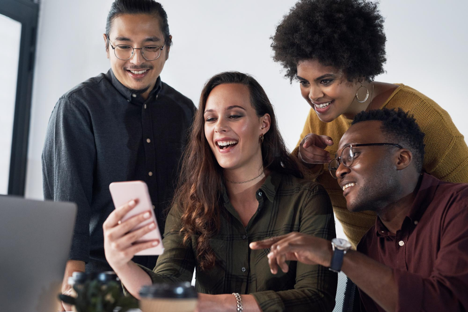 Personas mirando un celular felices